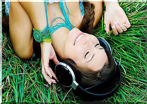 Woman lying in the grass listening to music