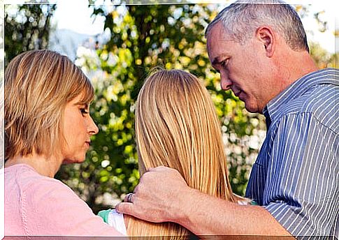 Two parents talking to their daughter