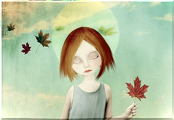 Girl holding a leaf with her eyes closed