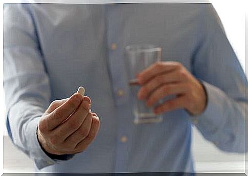 Man with pill in hand, and glass of water