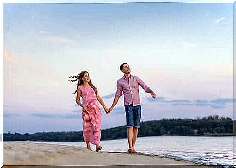 A couple walking hand in hand on the beach