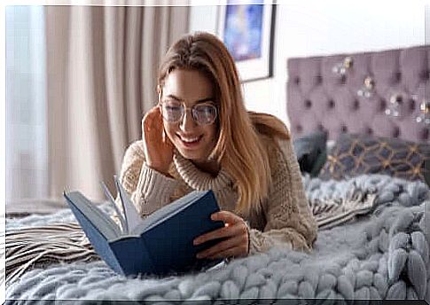 A woman is reading a book in bed