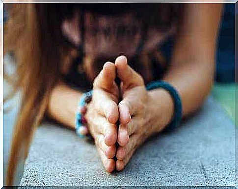 Two folded hands on a table