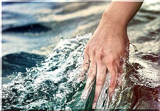 A Woman Holding Her Hand In The Water And Says The Water Lets Everything Flow