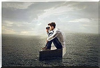 Man looking through binoculars on a rock in the middle of the ocean because we have to do things that seem impossible