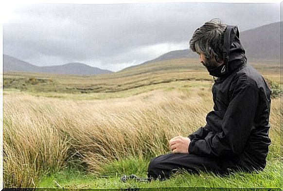 Man sitting in the dunes on a windy day