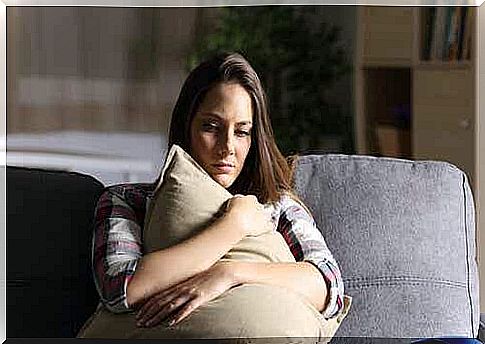 A woman cuddles with a pillow